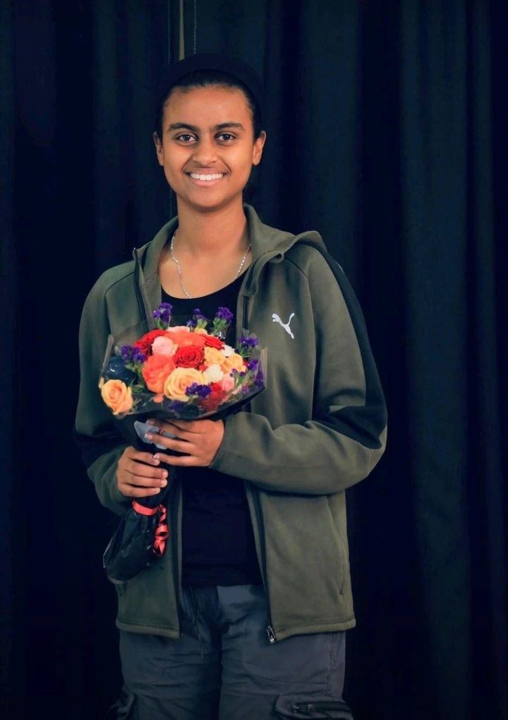 Sifene Erkossa holding a bouquet of flowers